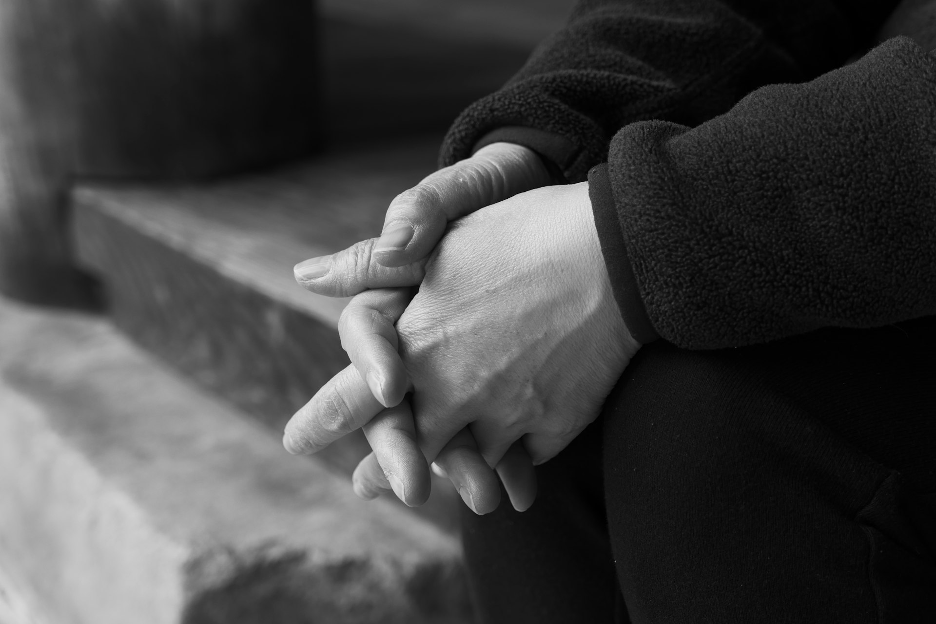 grayscale photo of person holding hands